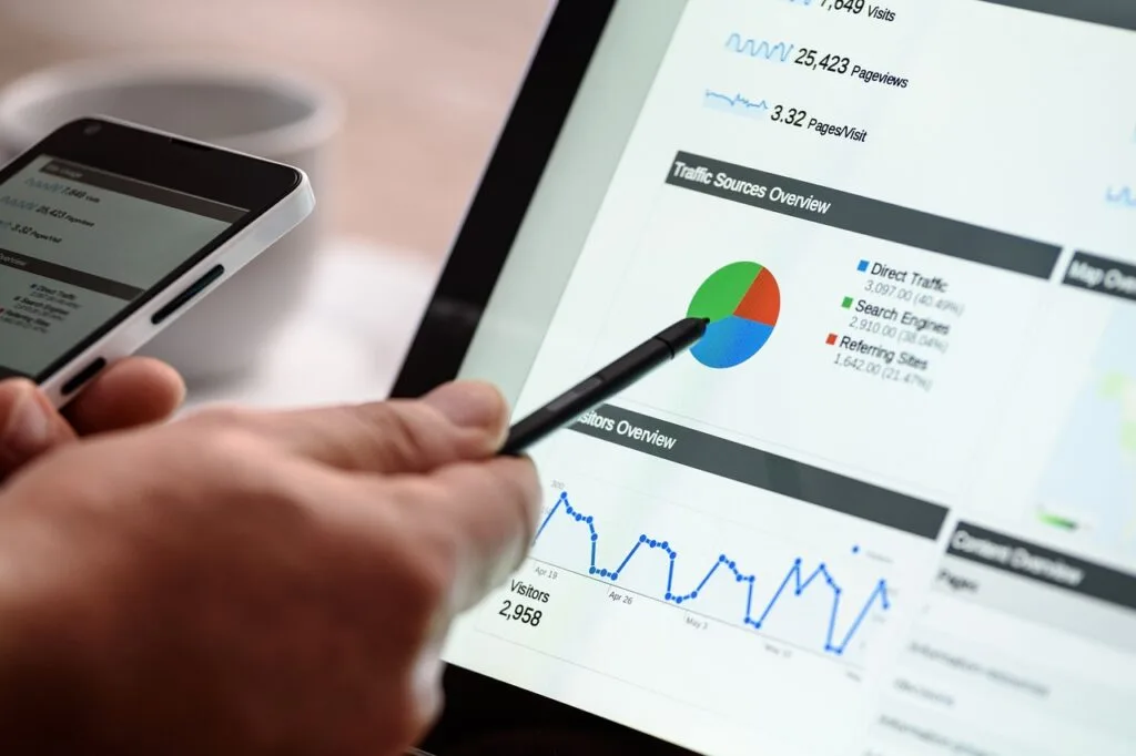 man pointing a ballpen at an SEO graph displayed on a computer screen