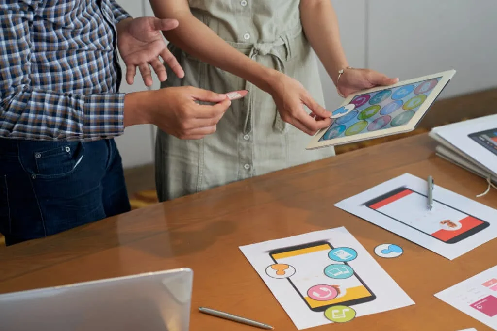 two people holding an ipad with different social media icons