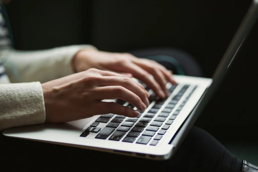 man typing in laptop