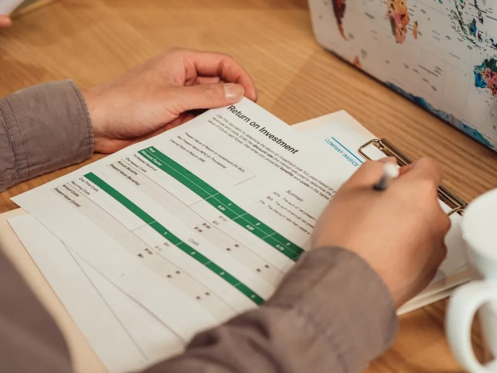 man holding a budget &amp; Roi Tracking Sheet