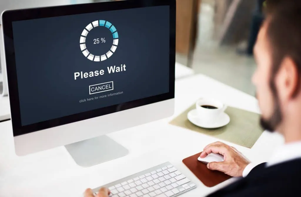 Man observing a computer display stuck on a loading page
