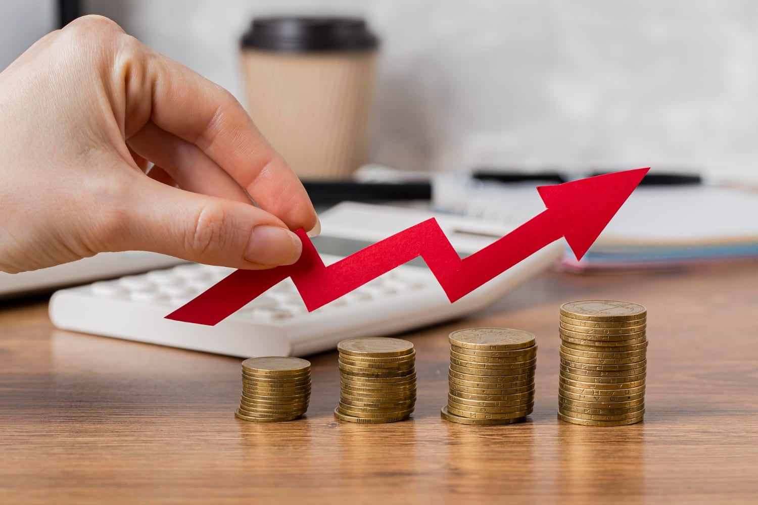 Hand placing a rising red arrow above stacks of coins, illustrating growing returns from search.
