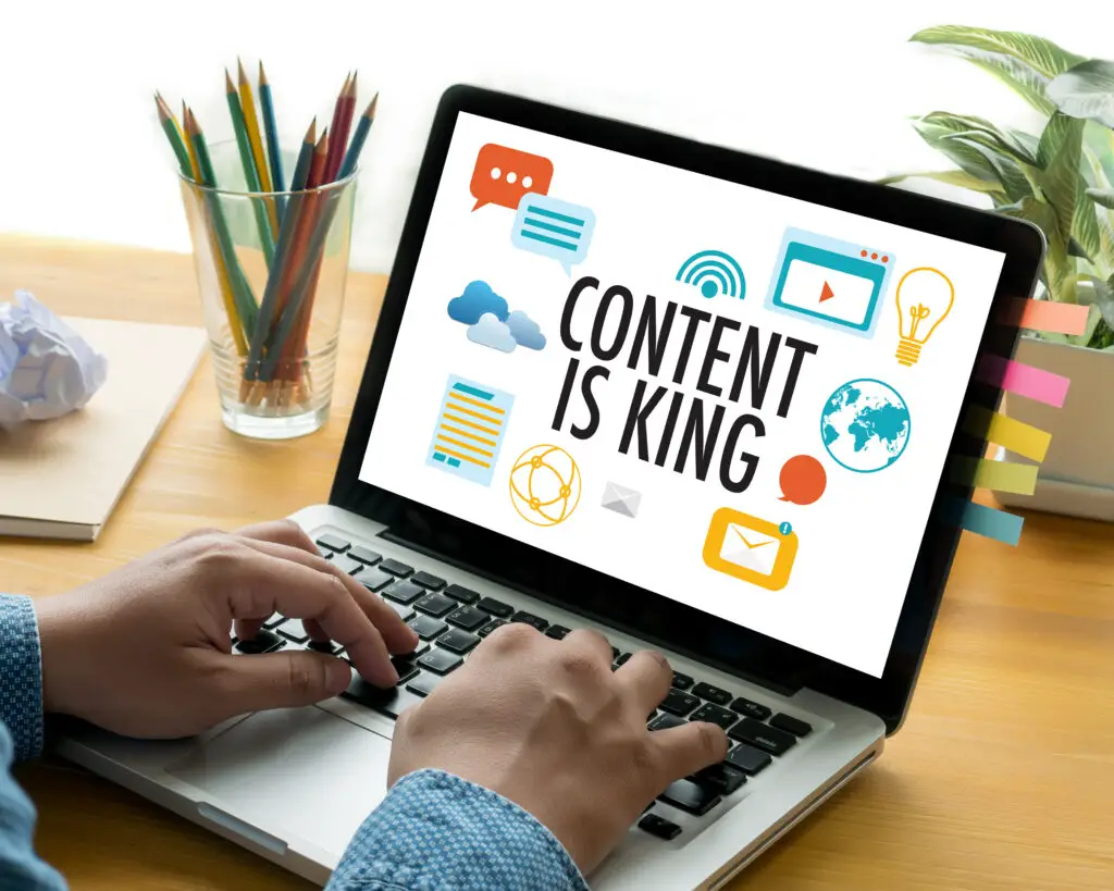 man working on a laptop with "Content is King" displayed as his wallpaper