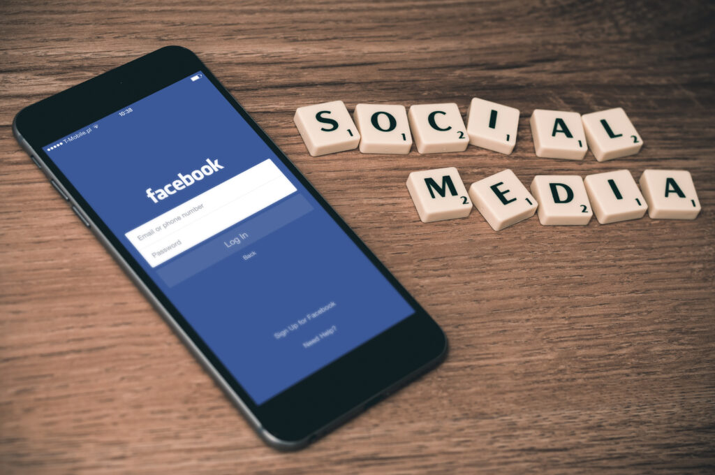 A mobile phone rests on a table, displaying the Facebook app.