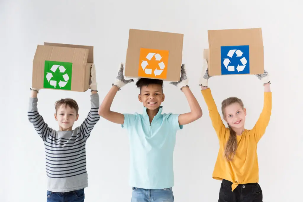 kids holding a card with a recycling symbol