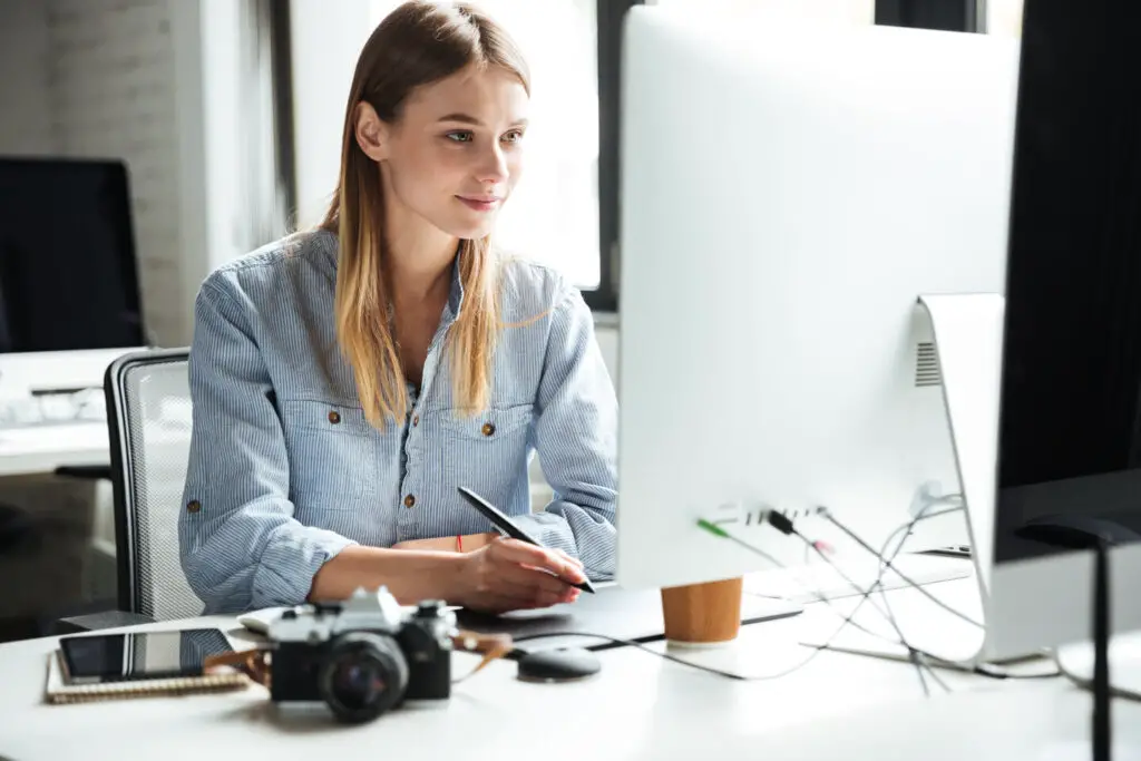 a woman looking at computer monitor inside the office