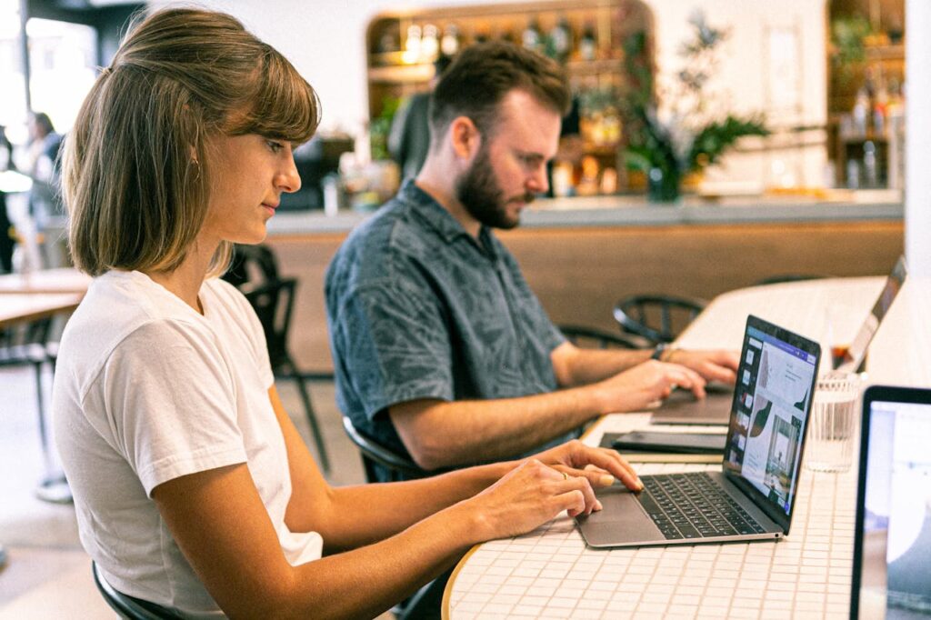 two people designing a web using a laptop