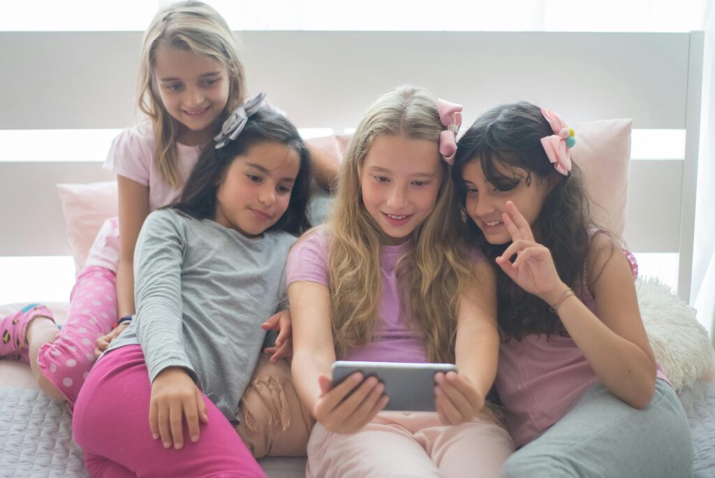 four girls watching on their mobile phone