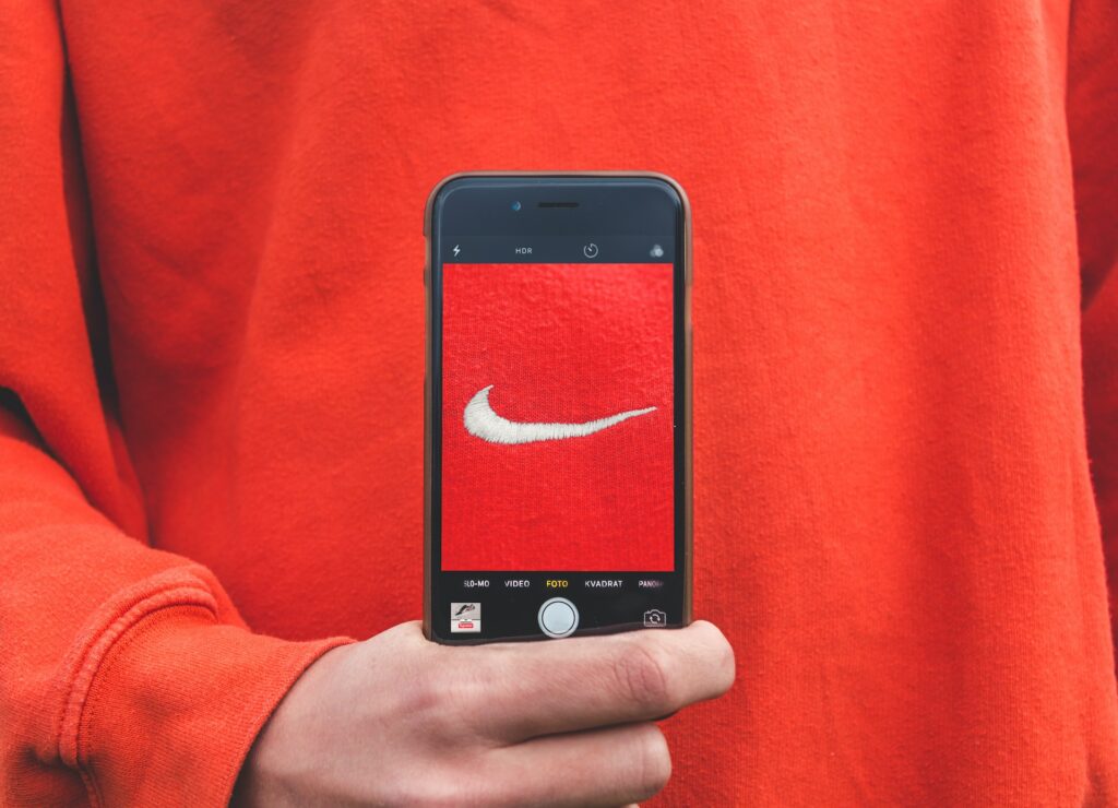 person holding an iphone taking picture of nike label