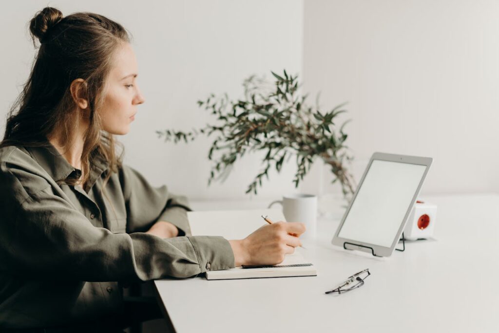 woman in gray coat using a white laptop computer