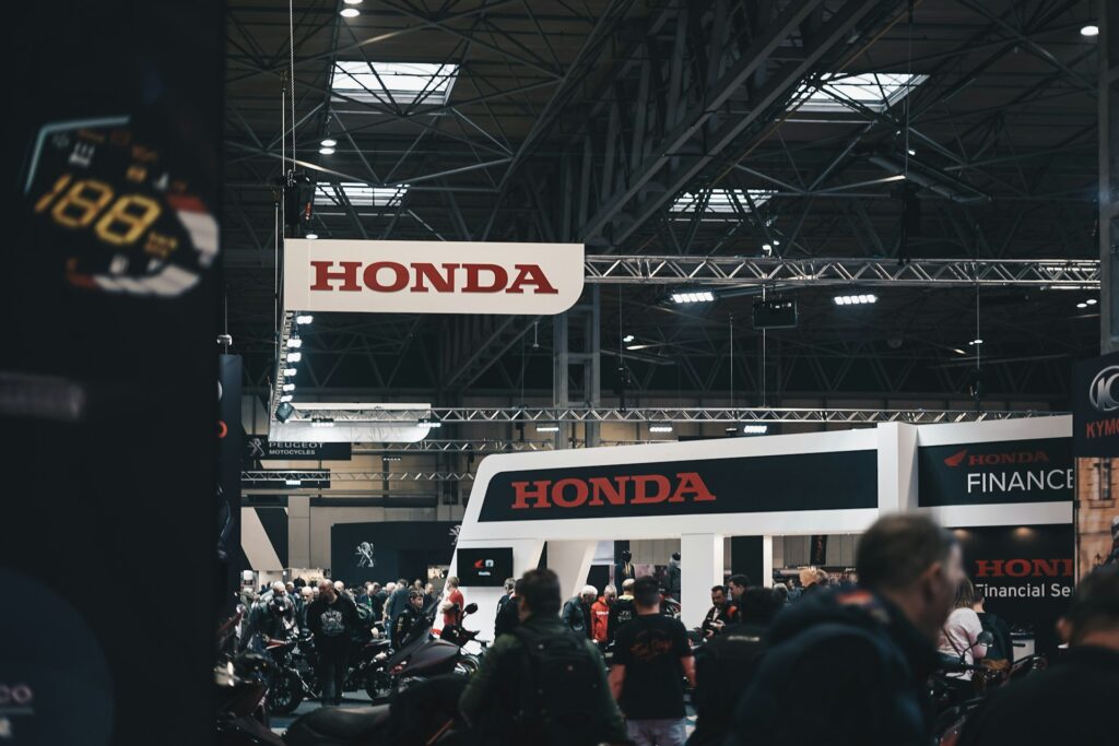 Peple walking next to Honda branded advertisement booth