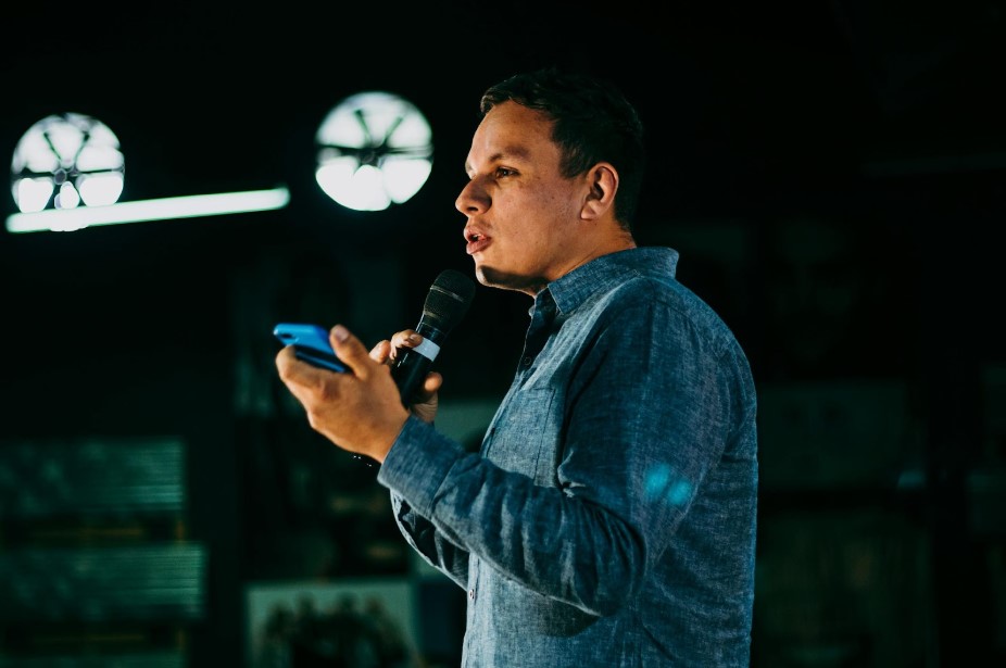 man holding a phone while speaking in public